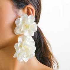 Beautiful woman wearing large white floral earrings, showcasing fashionable and stylish accessories from Monalisa Store for women and fashion enthusiasts.