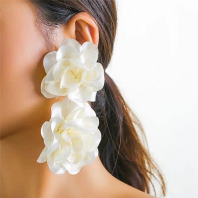 Beautiful woman wearing large white floral earrings, showcasing fashionable and stylish accessories from Monalisa Store for women and fashion enthusiasts.