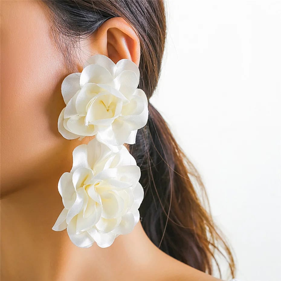 Beautiful woman wearing large white floral earrings, showcasing fashionable and stylish accessories from Monalisa Store for women and fashion enthusiasts.