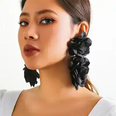 Elegant woman with large black floral earrings, showcasing trendy and fashionable jewelry for women. Perfect accessory for special occasions and stylish outfits.