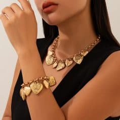 Golden heart-shaped jewelry set including a necklace and bracelet with engraved floral patterns and love inscriptions, perfect for elegant fashion accessories.