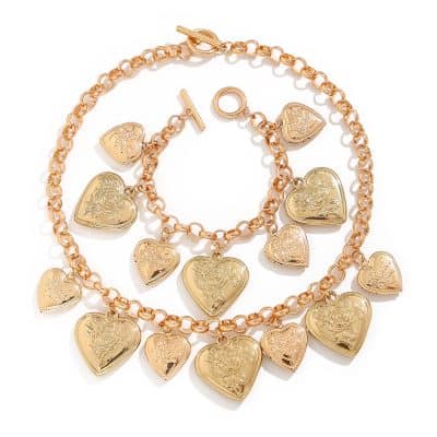 Shiny gold heart-shaped jewelry set featuring a necklace and bracelet with engraved floral and love-themed designs, perfect for elegant fashion accessories.