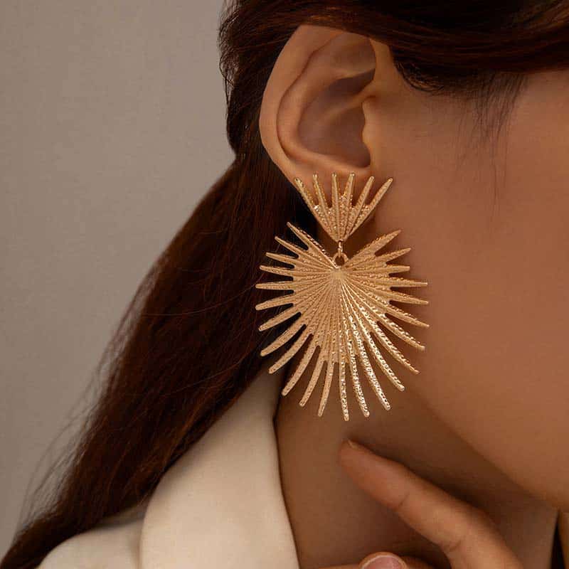 Elegant gold sunburst chandelier earring, perfect for stylish women looking for statement jewelry. Unique design adds glamour to any outfit for special occasions or everyday wear.
