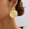Bold gold statement earrings with intricate circular pattern for fashionable accessories. Perfect for stylish, modern jewelry lovers seeking elegant and unique earring designs.