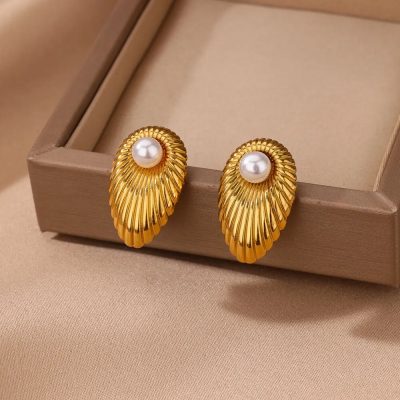 Elegant gold pearl earrings with a seashell design, perfect for sophisticated fashion statements. Ideal for women seeking luxury jewelry in a stylish, timeless design.