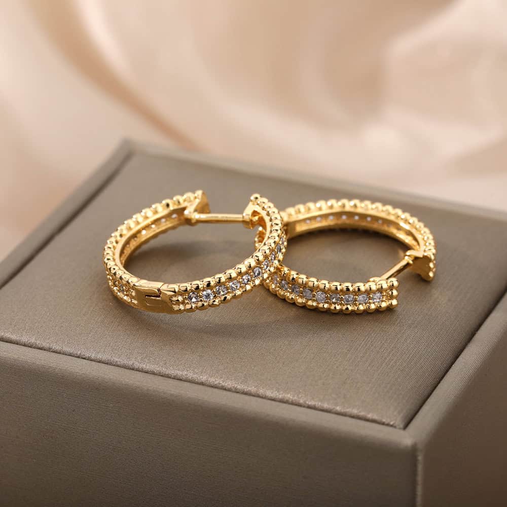 Dainty gold hoop earrings with embedded cubic zirconia, perfect for elegant jewelry collections or gifting at Monalisa Medical Store. Crafted with precision for a luxurious look.