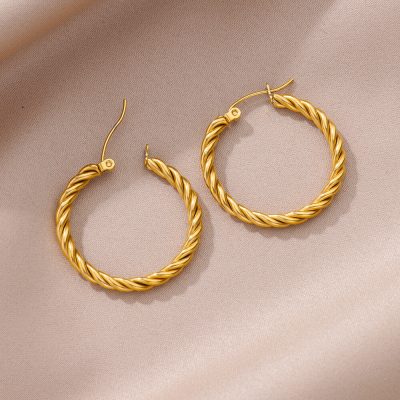 Shiny gold twisted hoop earrings, elegant jewelry accessory for women, stylish and fashionable design, perfect for everyday wear or special occasions.