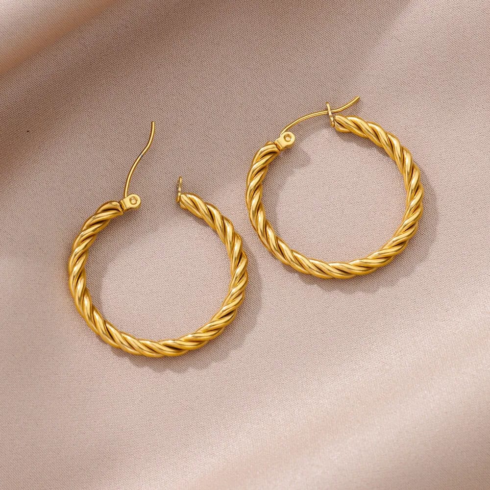 Elegant gold twisted hoop earrings with hook closure perfect for sophisticated jewelry styling.
