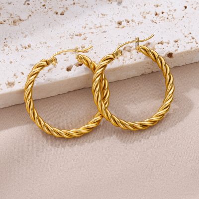 Gold twisted hoop earrings, luxurious jewelry for women, on a neutral background at Monalisa Store.