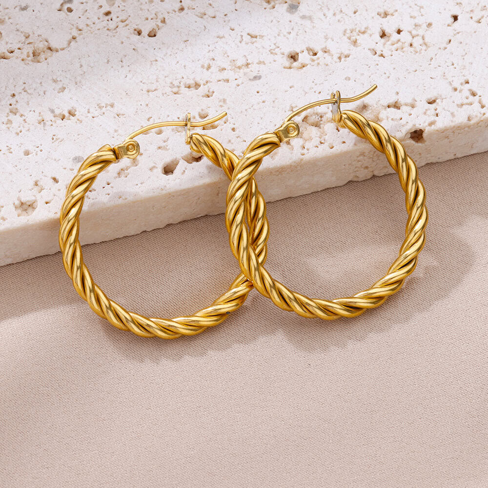 Gold twisted hoop earrings, luxurious jewelry for women, on a neutral background at Monalisa Store.