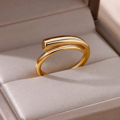 Shiny gold ring with curved bar design displayed in a jewelry box.