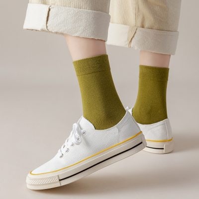 Comfy white sneakers paired with stylish olive green socks, showcasing casual and trendy footwear options at Monalisa Store.