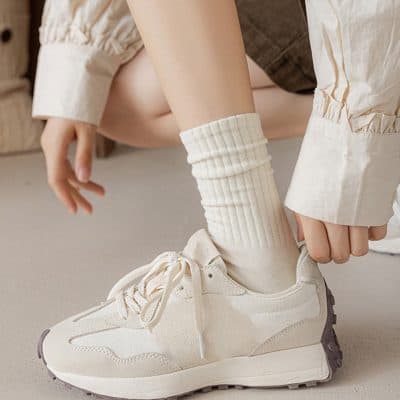 Comfy white sneakers with beige accents, paired with cozy cream-colored socks and casual beige pants, perfect for a stylish, comfortable look at Monalisa Medical Store.