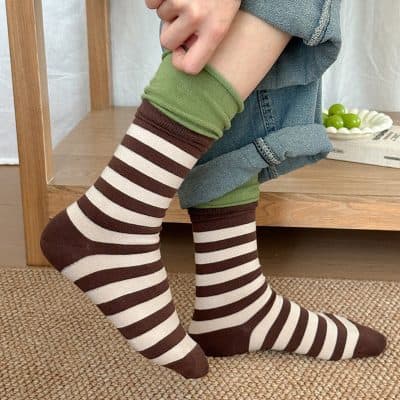 Comfy striped knee-high socks with brown and white horizontal patterns, perfect for cozy fashion and casual wear.