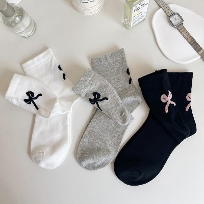 Soft cotton socks with bow patterns in white, gray, and black for women and children, ideal for everyday wear and casual fashion. Perfect for adding a cute touch to your wardrobe.