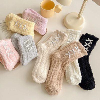 Soft pastel-colored terry cloth socks with satin bows, ideal for home comfort and skin-sensitive use, displayed with a coffee mug and desk lamp on a clean white surface.