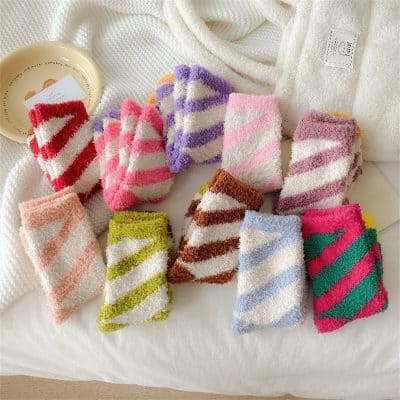 Colorful striped fuzzy socks in various pastel and vibrant shades, perfect for cozy comfort and stylish loungewear.