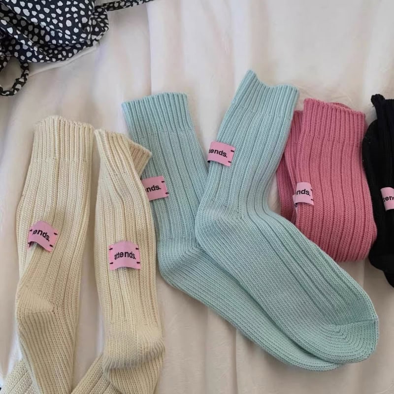 Colorful knitted socks displayed on a white surface, featuring pastel and vibrant shades, ideal for stylish and comfortable eye-catching accessories. Perfect for fashion and casual wear.