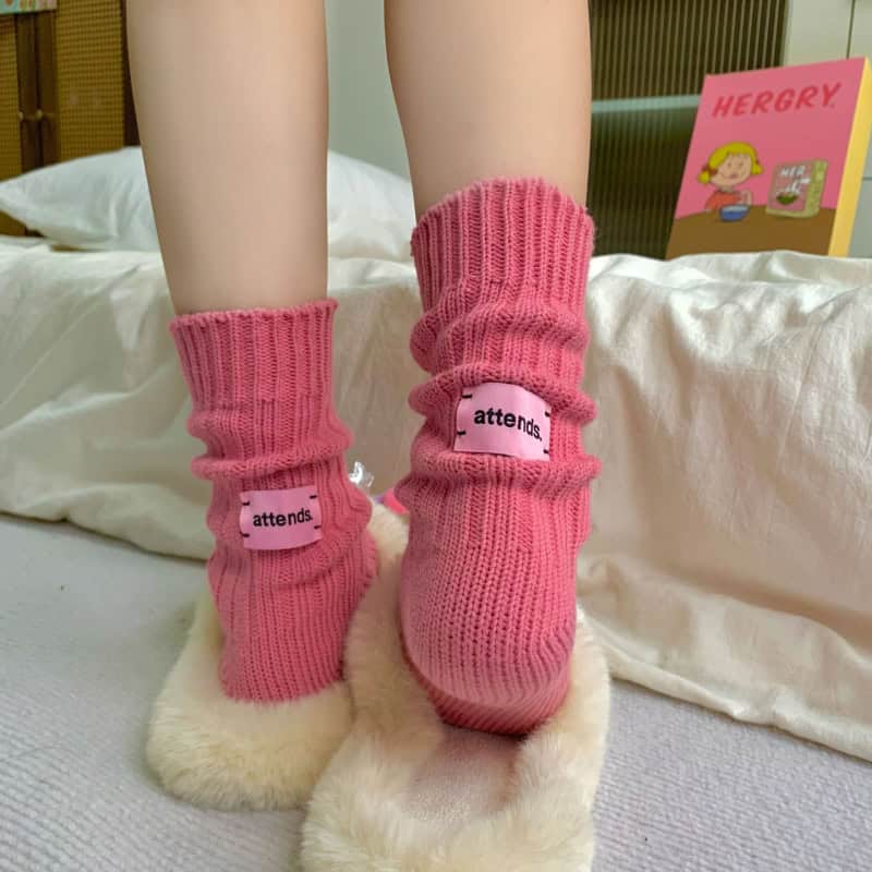 Pink cozy socks with "attends" logo, comfortable slippers, plush slippers for indoor wear.