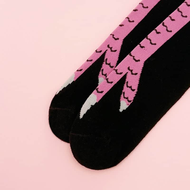Pink flamingo patterned socks on black background, stylish and comfortable for everyday wear. Perfect for fashion-forward individuals seeking fun and unique sock designs.