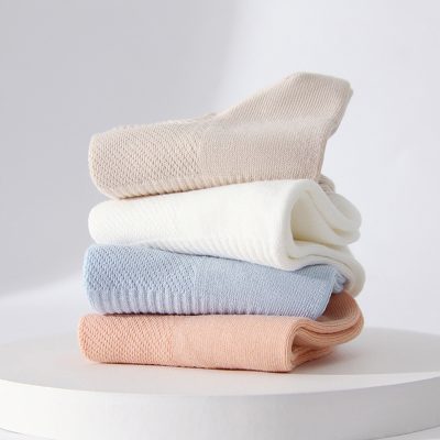 Soft pastel-colored folded socks on a white surface, cozy and comfortable, ideal for everyday wear, available at Monalisa Store.