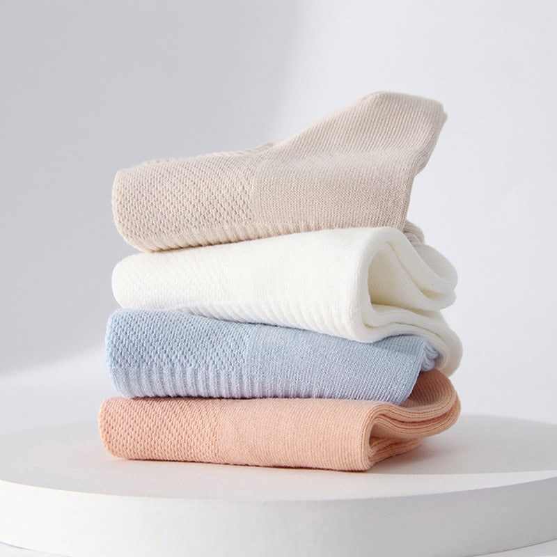 Soft pastel-colored folded socks on a white surface, cozy and comfortable, ideal for everyday wear, available at Monalisa Store.