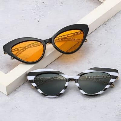Elegant fashion sunglasses featuring bold black and white striped frames with dark and orange tinted lenses, perfect for stylish sun protection at Monalisa Store.
