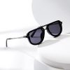 Black designer sunglasses with dark tinted lenses on a white geometric background suitable for fashion and eye protection.