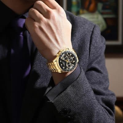 Luxurious gold men's watch featuring a black dial with multiple chronograph subdials, stylishly worn on a man's wrist for a sophisticated look.