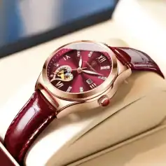 Elegant luxury women's wristwatch with a deep red dial and leather strap, featuring diamond accents and open-heart design for sophisticated style.