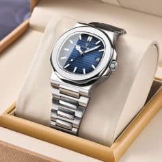 Stainless steel luxury watch with blue dial and date display, presented in a beige display box. Elegant and sophisticated wristwatch ideal for collectors and fashion enthusiasts.