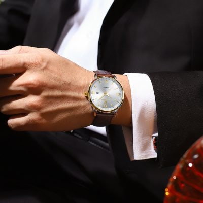 Elegant men's wristwatch with gold accents, silver dial, and leather strap, perfect for luxury fashion and professional wear.