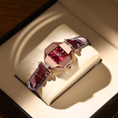 Elegant women’s luxury wristwatch with a red dial and diamond accents, featuring a rich burgundy leather strap, displayed in a high-end watch box. Perfect for stylish accessories and fine jewelry collections.