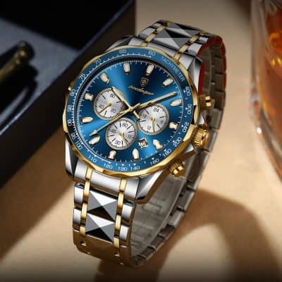 Stainless steel and gold luxury chronograph watch with a blue dial and tachymeter bezel displayed on a beige surface.