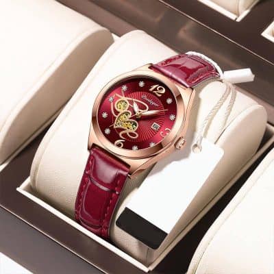 Luxurious women's watch with a red dial, gold accents, and a polished red leather strap, displayed in an elegant box for a premium feel.