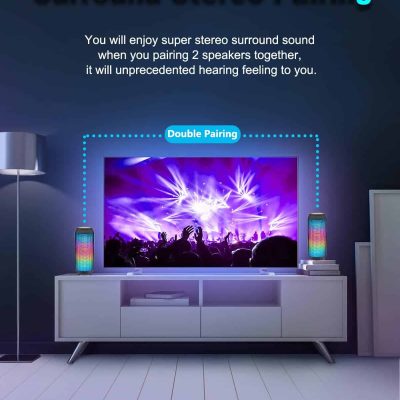 Voice-controlled stereo speakers with colorful LED lights on a modern TV stand in a living room setting.