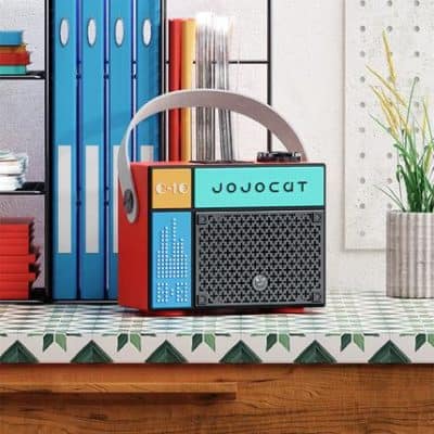 Vintage boombox and colorful books on a modern desk, representing stylish office accessories at Monalisa Store.