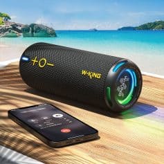 Bluetooth portable speaker with colorful LED lights on a wooden surface against a beach backdrop, wireless connection with smartphone.