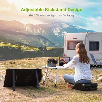 Solar-powered camping setup with portable electronics and scenic mountain background.