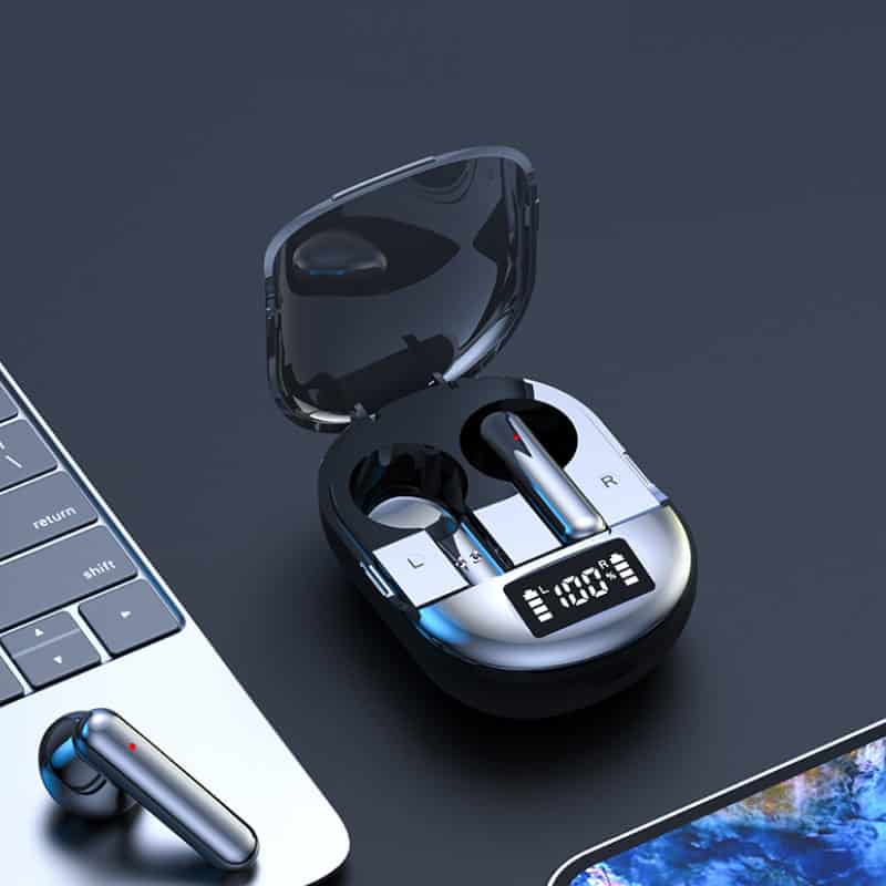 Wireless Bluetooth earphones with charging case on laptop desk, modern tech accessories for audio listening.