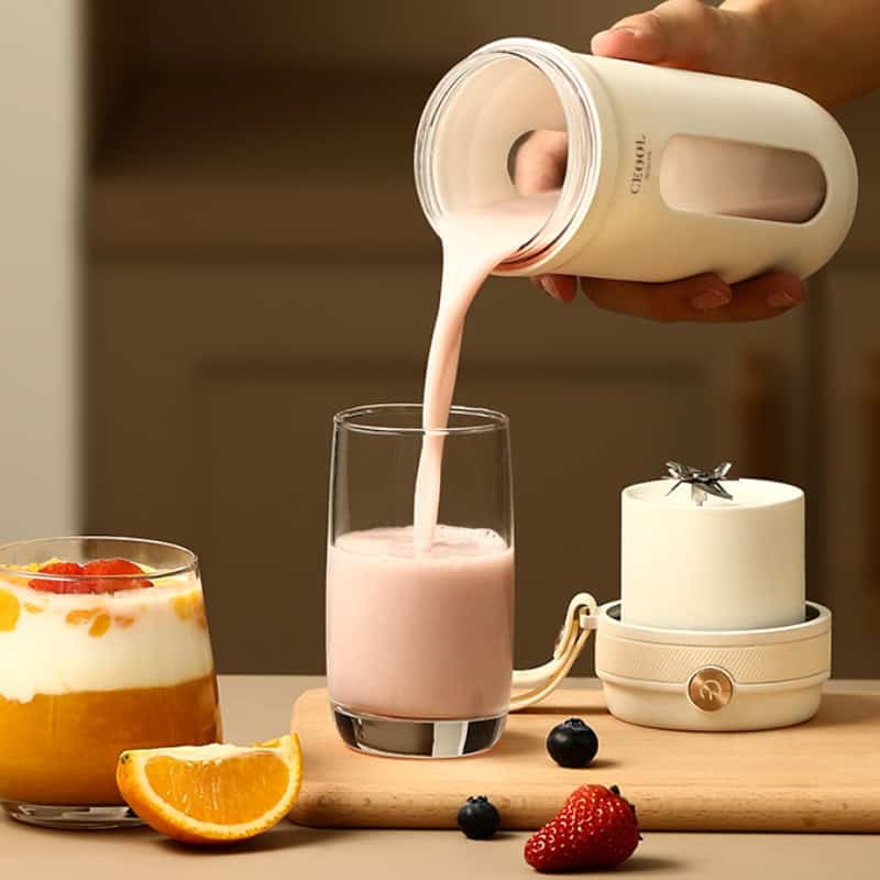 Cream milk being poured into a glass with fruits on a wooden cutting board.