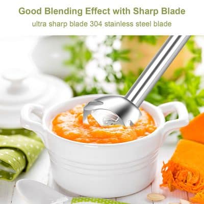 Smooth stainless steel blade ice cream scoop in white ceramic bowl with bright orange puree, on a white table with green and orange accents, perfect for desserts or kitchen tools.