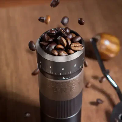 Fresh roasted coffee beans being ground in a coffee grinder, showcasing premium coffee preparation for café or home brewing.