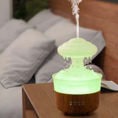 Ultrasonic essential oil diffuser with misting feature, next to a bed with white pillows, creating a relaxing atmosphere for improved sleep and wellness, ideal for sleep therapy and aromatherapy.