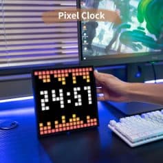Pixel Clock LED display on a computer desk with monitors, keyboard, and modern tech setup, indoors.