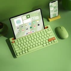 Colorful wireless keyboard, tablet, smartphone, and mouse on green desk, emphasizing digital device use at Monalisa Medical Store; bright, modern workspace for healthcare technology.