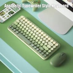 Aesthetic typewriter style keyboard with round keys on a green desk, paired with a sleek mouse and modern tech accessories, showcasing innovative and stylish computer peripherals for a workspace.