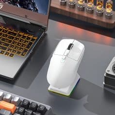 Wireless computer mouse on a desk with a laptop and keyboard, showcasing tech accessories in a modern office setup.