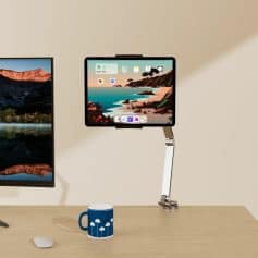 Laptop and tablet mounted on adjustable stand with the tablet showing a scenic beach landscape, ideal for tech workspace setup and digital productivity.