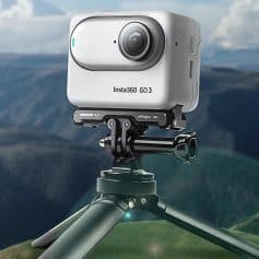 Insta360 GO 3 action camera mounted on tripod with scenic mountain landscape background.